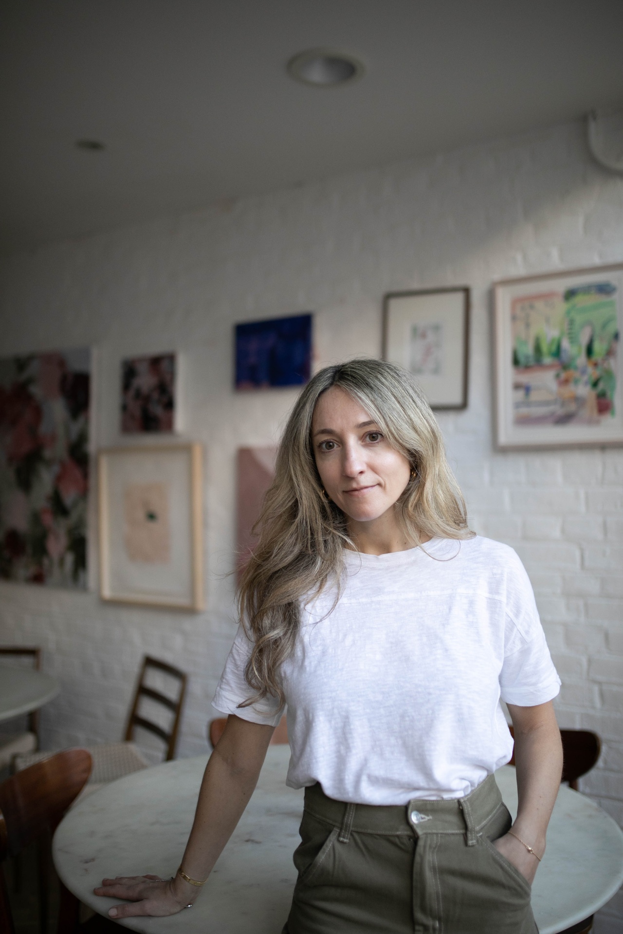 Portrait of Chloe Samini standing in a warm gallery space